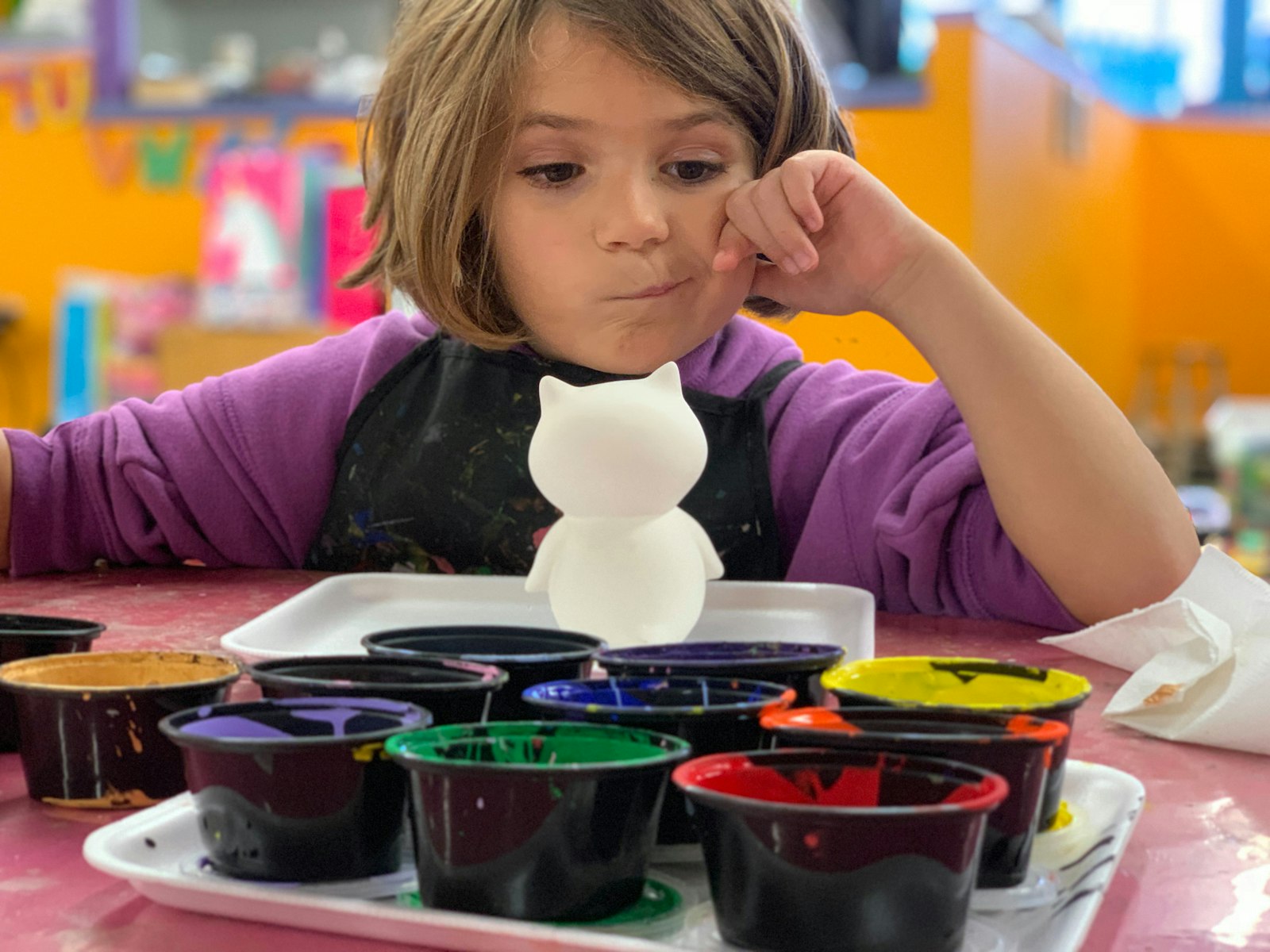 Child mixing paints in a preschool art classroom