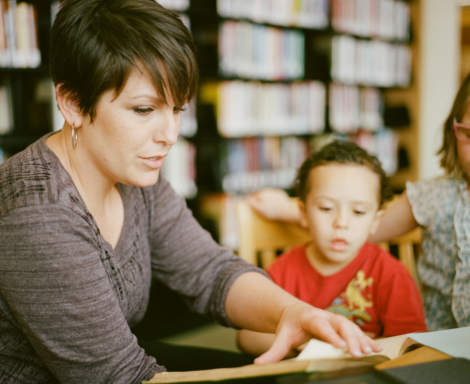 A teacher reading a book with a young child at a child care center